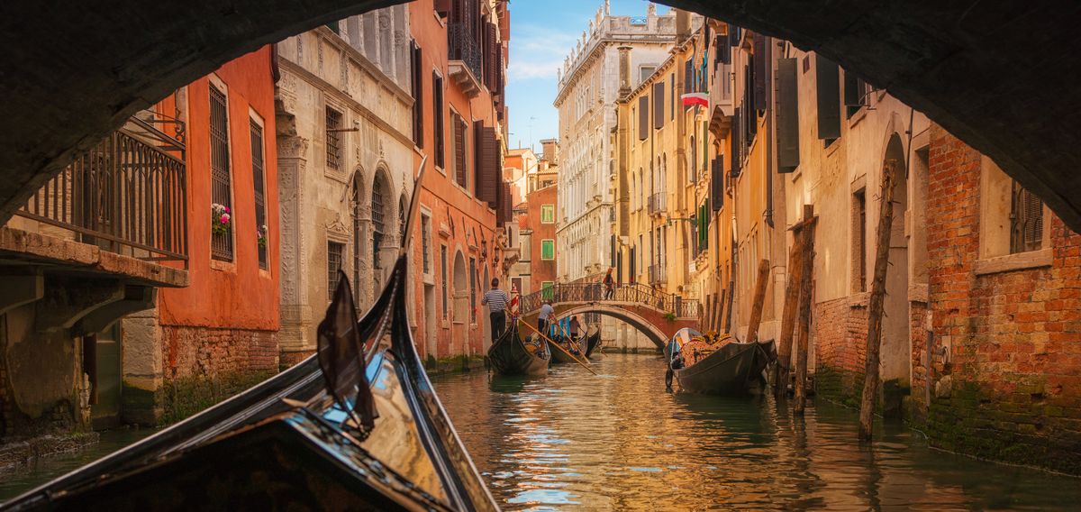 Gondel fährt unter Brücke in Venedig